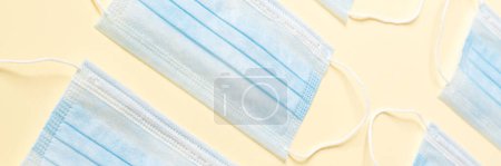 Photo for A vertical view of a disposable protective masks lying in the beige studio - Royalty Free Image