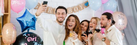 Foto de Feliz jóvenes amigos tomando foto selfie juntos durante el género revelan fiesta en el interior - Imagen libre de derechos