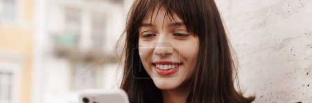 Photo for Close up of a smiling young stylish brunette white woman with short hair standing on a street - Royalty Free Image