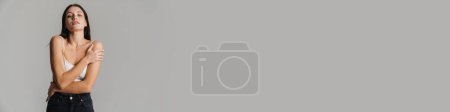 Photo for Young brunette woman wearing brassiere posing and looking at camera isolated over grey background - Royalty Free Image