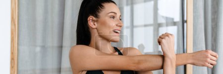 Photo for White brunette woman smiling and doing exercise while working out at home - Royalty Free Image