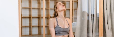 Téléchargez les photos : Jeune femme blanche faisant de l'exercice pendant la pratique du yoga à la maison - en image libre de droit