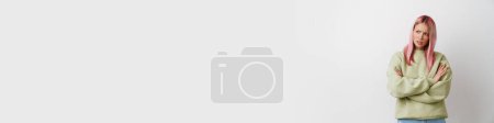 Téléchargez les photos : Jeune femme mécontente avec les cheveux roses fronçant les sourcils et regardant de côté isolé sur fond blanc - en image libre de droit
