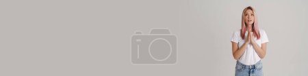 Téléchargez les photos : Jeune femme aux cheveux roses fronçant les sourcils tout en tenant les paumes ensemble isolé sur fond blanc - en image libre de droit
