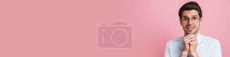 Téléchargez les photos : Jeune homme portant noeud papillon souriant et regardant la caméra isolée sur fond rose - en image libre de droit
