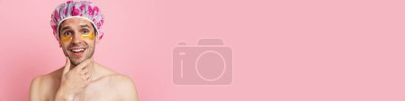 Téléchargez les photos : Jeune homme torse nu portant bonnet de douche souriant et regardant la caméra isolée sur fond rose - en image libre de droit