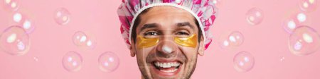 Photo for Young shirtless man wearing shower cap smiling and looking at camera isolated over pink background - Royalty Free Image