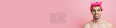Téléchargez les photos : Jeune homme torse nu portant bandeau souriant et regardant la caméra isolée sur fond rose - en image libre de droit