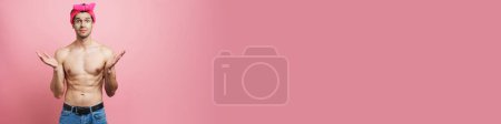 Téléchargez les photos : Jeune homme torse nu portant bandeau exprimant surprise à la caméra isolé sur fond rose - en image libre de droit