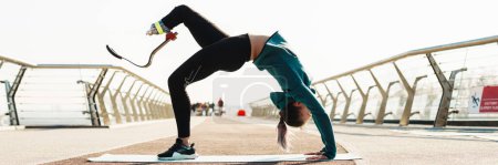 Foto de Joven deportista con prótesis haciendo ejercicio mientras hace ejercicio en el puente de la ciudad - Imagen libre de derechos