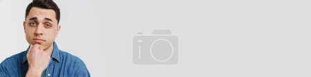 Téléchargez les photos : Jeune homme blanc brune posant et regardant la caméra isolée sur fond blanc - en image libre de droit