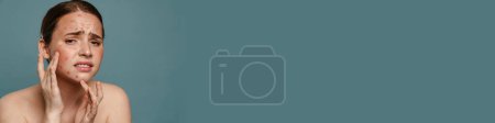 Téléchargez les photos : Roux torse nu femme fronçant les sourcils et pressant bouton sur son visage isolé sur fond bleu - en image libre de droit