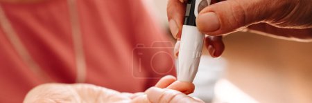 Photo for A close-up view of the measuring blood glucose level to the elderly patient in the room - Royalty Free Image