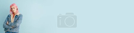 Téléchargez les photos : Jeune femme blanche aux cheveux roses posant et regardant la caméra isolée sur fond bleu - en image libre de droit