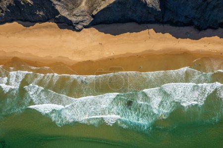 Aerial drone view of Cordoama Beach in Portugal with sandy shore, cliffs and ocean