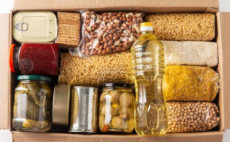 Lebensmittelaufbewahrung, Spenden- und Essenskonzept - Nahaufnahme einer Schachtel mit Lebensmitteln und Konserven auf weißem Hintergrund, Ansicht von oben