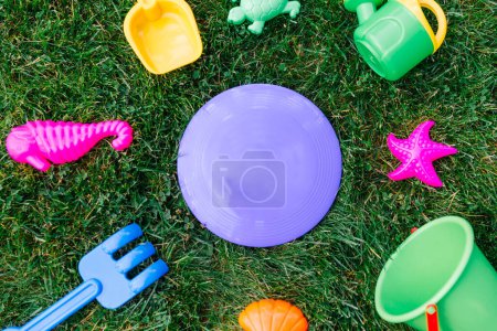 childhood and summer concept - close up of sand toys kit on green lawn or grass