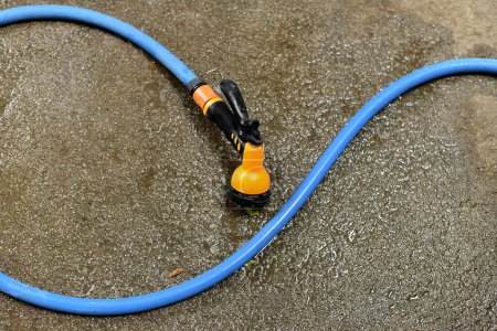 Photo for Water spay gun and pipe on wet ground, Washing tool - Royalty Free Image