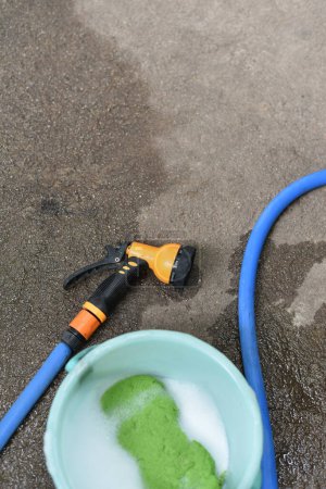 Photo for Car wash tool on ground, Water spray with busket and sponge - Royalty Free Image