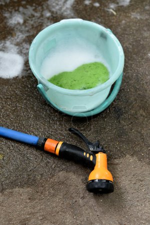 Photo for Car wash tool on ground, Water spray with bucket and sponge - Royalty Free Image