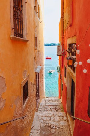 Photo for Narrow street between old houses leading to the sea in Rovinj, Croatia - Royalty Free Image