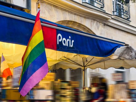 Téléchargez les photos : Storefront of bookstore or souvenir shop in Paris, France with LGBT flag in front of it - en image libre de droit