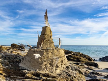 Téléchargez les photos : Château de sable sur la plage avec une tour et des drapeaux en plumes - en image libre de droit
