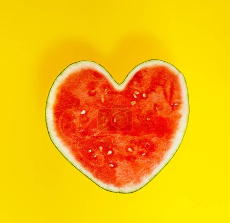 Téléchargez les photos : Watermelon in shape of heart - sweet lovely healthy food concept over yellow background - en image libre de droit