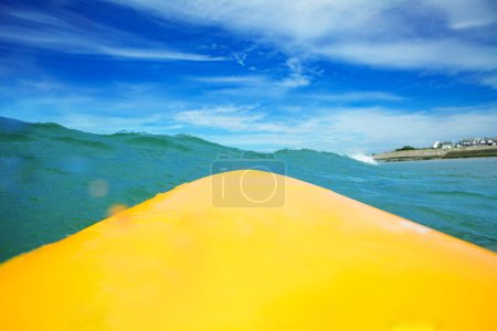 Foto de Close-up of the surfing board from surfer point of view in the ocean waves - Imagen libre de derechos