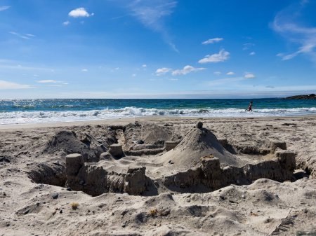 Photo for Big sand castle with many towers on the beach over the sea on background - Royalty Free Image
