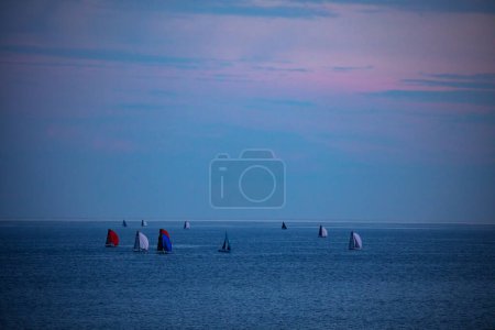 Téléchargez les photos : Group of boats and yachts in the sea with sails of different color during morning dusk - en image libre de droit