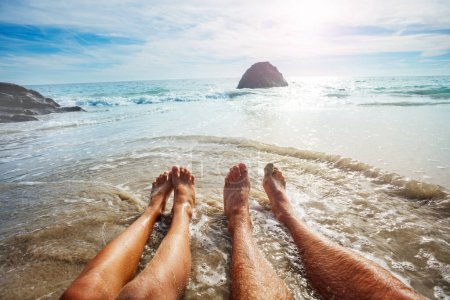 Photo for Photo of a father and son's feet in the water of the ocean on summer vacation - Royalty Free Image