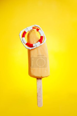 Téléchargez les photos : Sauver du concept de temps chaud - crème glacée avec bouée de sauvetage - en image libre de droit