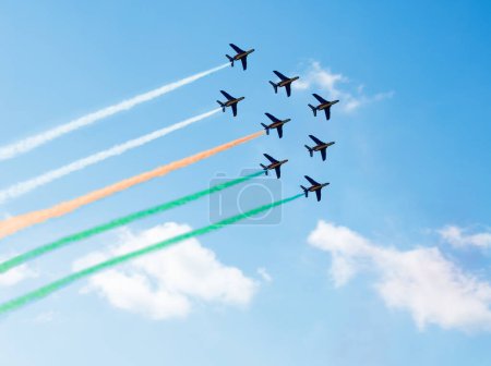 Photo for Squadron of planes fly with color trail lines of India or Cote d'Ivoire over clouds and clear sky - Royalty Free Image