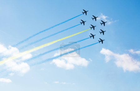 Téléchargez les photos : Squadron of planes fly with color trail lines of Sweden, Ukraine, Bahamas or Kazakhstan over clouds and clear sky - en image libre de droit