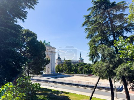 Téléchargez les photos : Vue sur l'Arc de Victoire ou Arco de la Victoria, construit sur la place Moncloa à Madrid, Espagne à travers les arbres - en image libre de droit