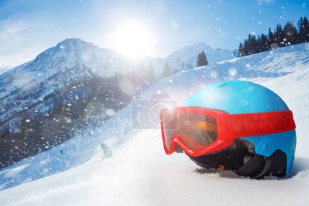 Foto de Hermoso casco de esquí o snowboard para niños con máscara alpina roja sobre montañas de fondo - Imagen libre de derechos