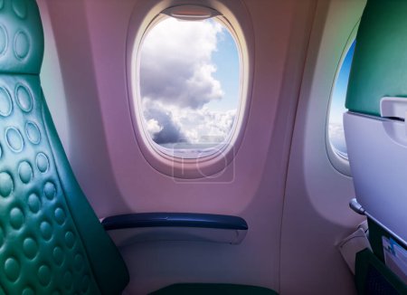 Photo for View of the unoccupied seat near the window in a plane with clouds outside - Royalty Free Image