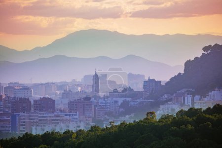 Photo for Sunset panorama of downtown and Cathedral of Malaga church over mountains ranges, Andalusia in southern Spain from castle walls - Royalty Free Image