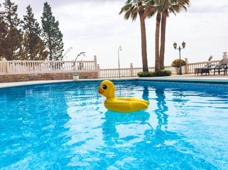 Foto de Diversión de verano con pato inflable en piscina cristalina en complejo turístico - Imagen libre de derechos
