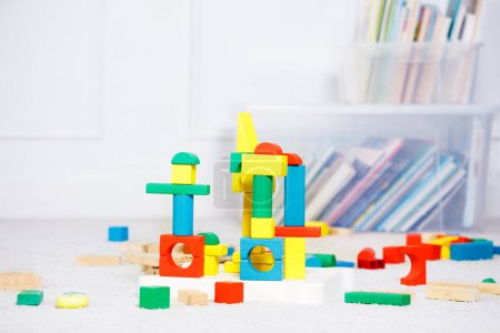 Foto de Grupo de bloques de color de madera de juguete, torres construidas sobre cajas de juguetes y libros alrededor - Imagen libre de derechos