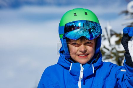 Foto de Retrato de cerca de un niño feliz con casco de esquí sonrisa sobre el cielo - Imagen libre de derechos