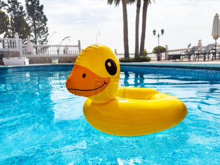 Téléchargez les photos : Crépuscule gonflable flottant au milieu de la piscine d'eau cristalline le jour de l'été - concept de vacances - en image libre de droit