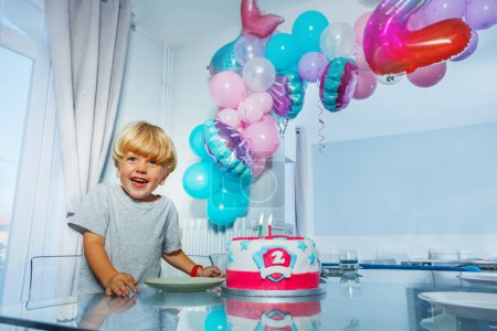 Foto de Feliz niño risa mirando a la cámara con fiesta de pastel de cumpleaños para la celebración de 2 años de edad - Imagen libre de derechos
