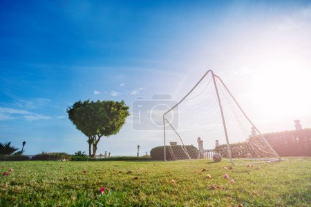 Foto de Puertas de fútbol en el campo en el jardín sobre el cielo azul y el sol caliente brillante del verano - Imagen libre de derechos