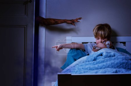 Téléchargez les photos : Main du monstre avec des griffes essayant d'atteindre enfant garçon dans le lit tenant jouet en peluche et doigt pointeur pour s'en aller - en image libre de droit