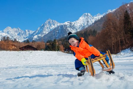 Téléchargez les photos : Petit garçon, glissez rapidement en descente et sur le point de tomber sur la pente alpine, des vacances d'hiver amusantes - en image libre de droit