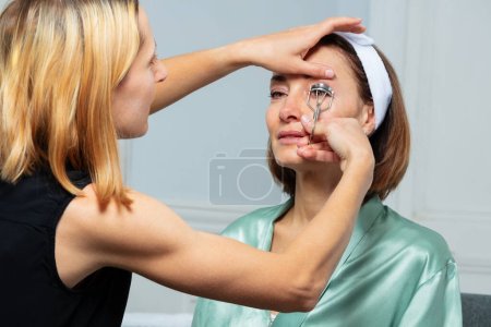 Photo for Beautician working use eyelash curler to straighten them on a model - Royalty Free Image