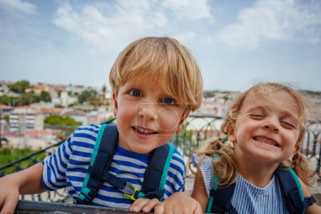 Foto de Feliz retrato de dos niños viajeros en el mirador de Lisboa disfrutar de su viaje de verano en Portugal - Imagen libre de derechos