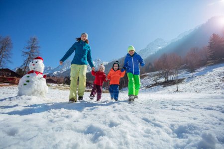 Foto de Los lazos familiares que corren en el campo de montaña nevado en los Alpes franceses disfrutan de las vacaciones de invierno en Navidad - Imagen libre de derechos
